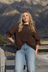 Blank Space. brown ruffle-neck top worn with jeans